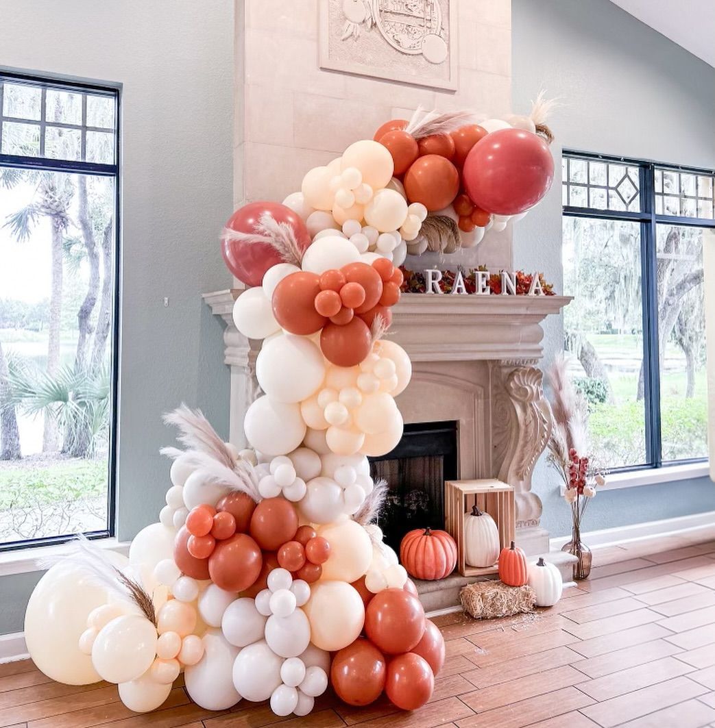 A bunch of balloons are sitting in front of a fireplace