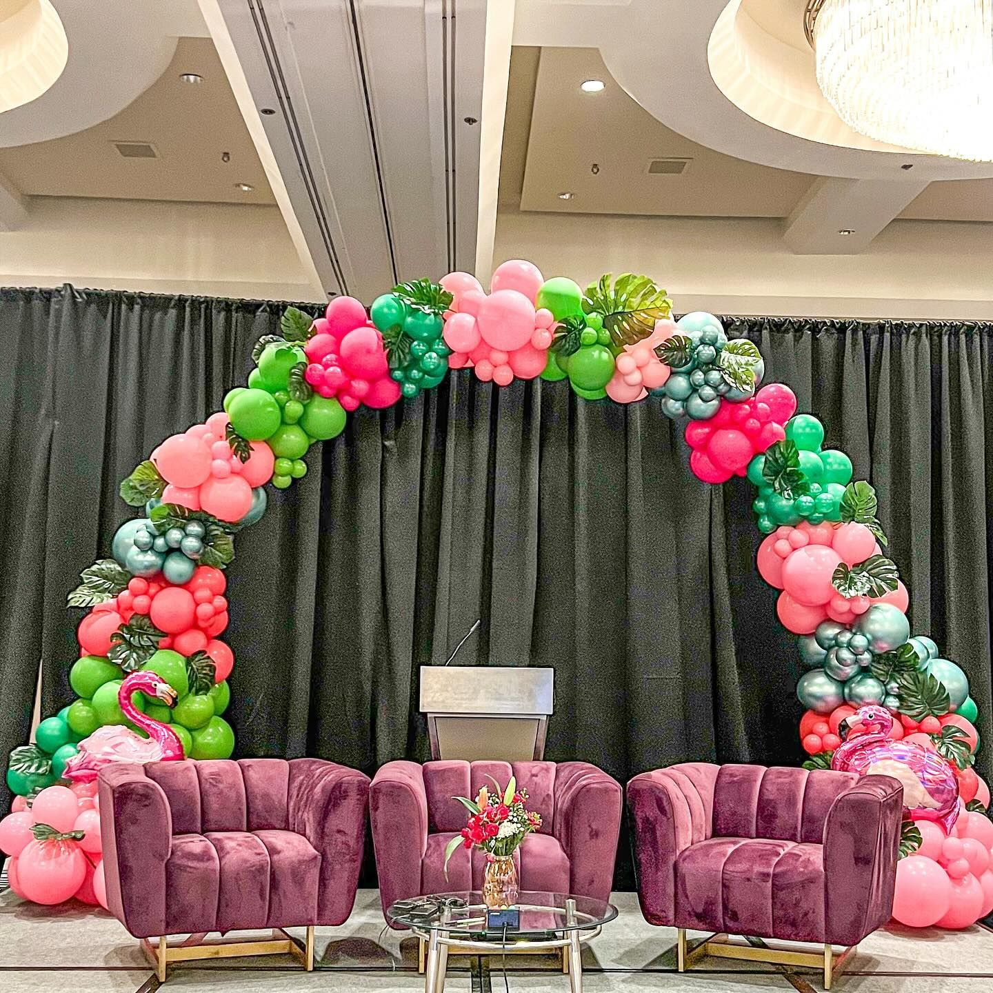 A room decorated with a flamingo balloon arch.