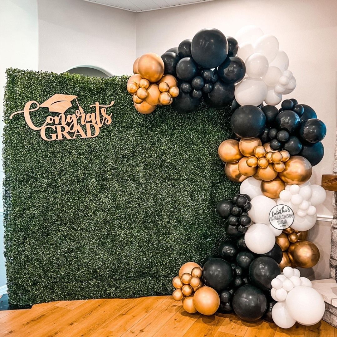 A graduation backdrop with balloons and a sign that says `` congratulations grad ''.