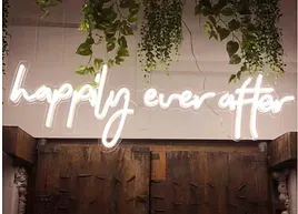 a neon sign that says `` happily ever after '' is hanging on a wall .