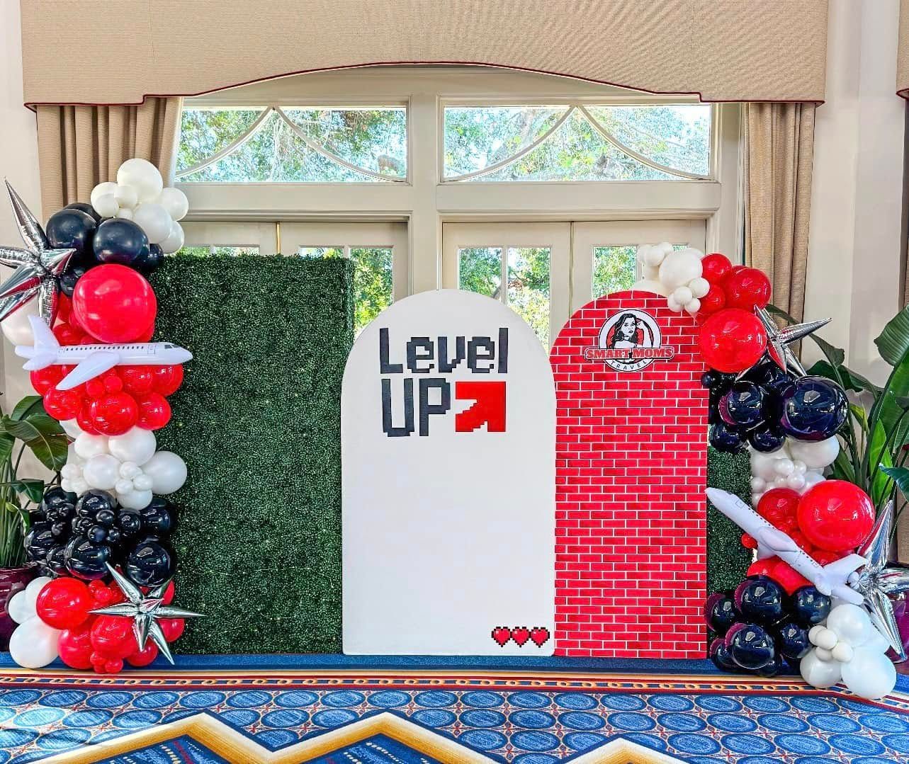A room decorated with balloons and a sign that says level up.