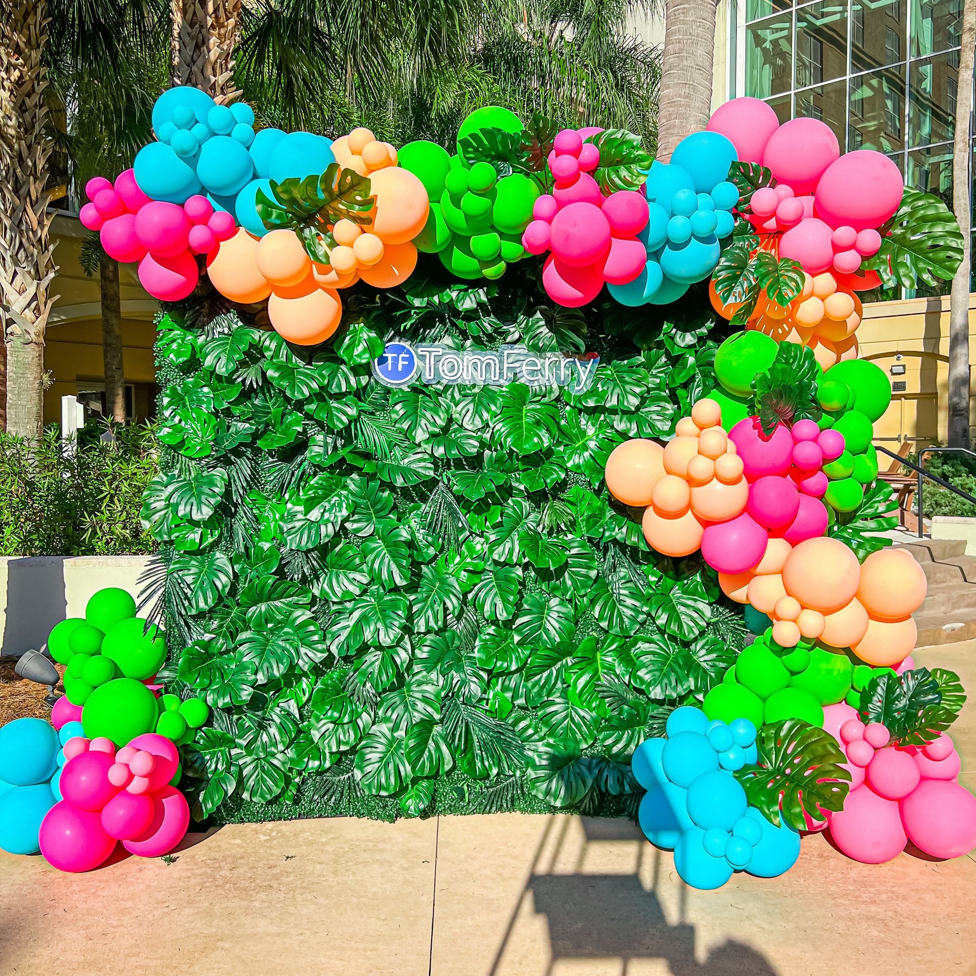 A wall covered in colorful balloons and leaves.