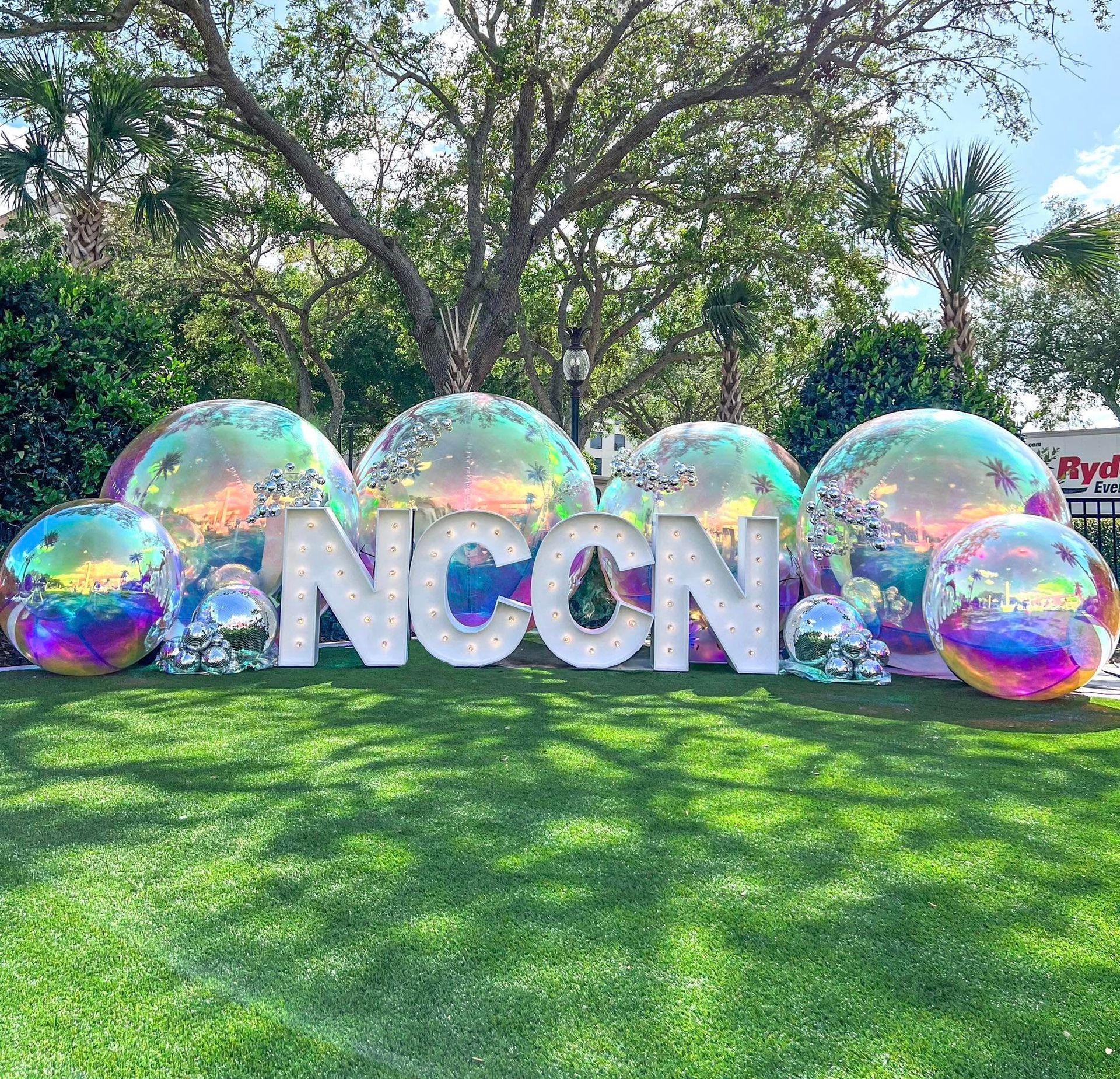 A bunch of balloons are sitting on top of a lush green field.
