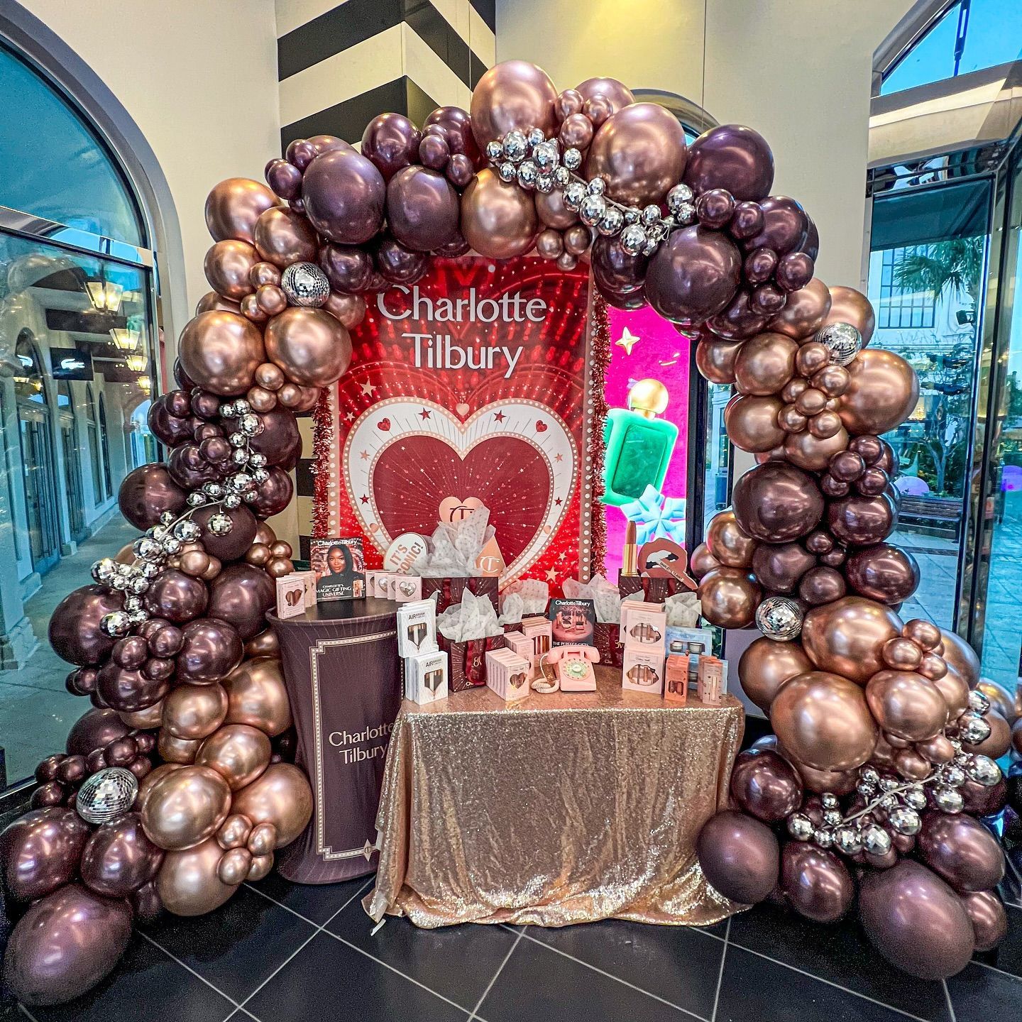 A room filled with balloons and a table with a heart on it.