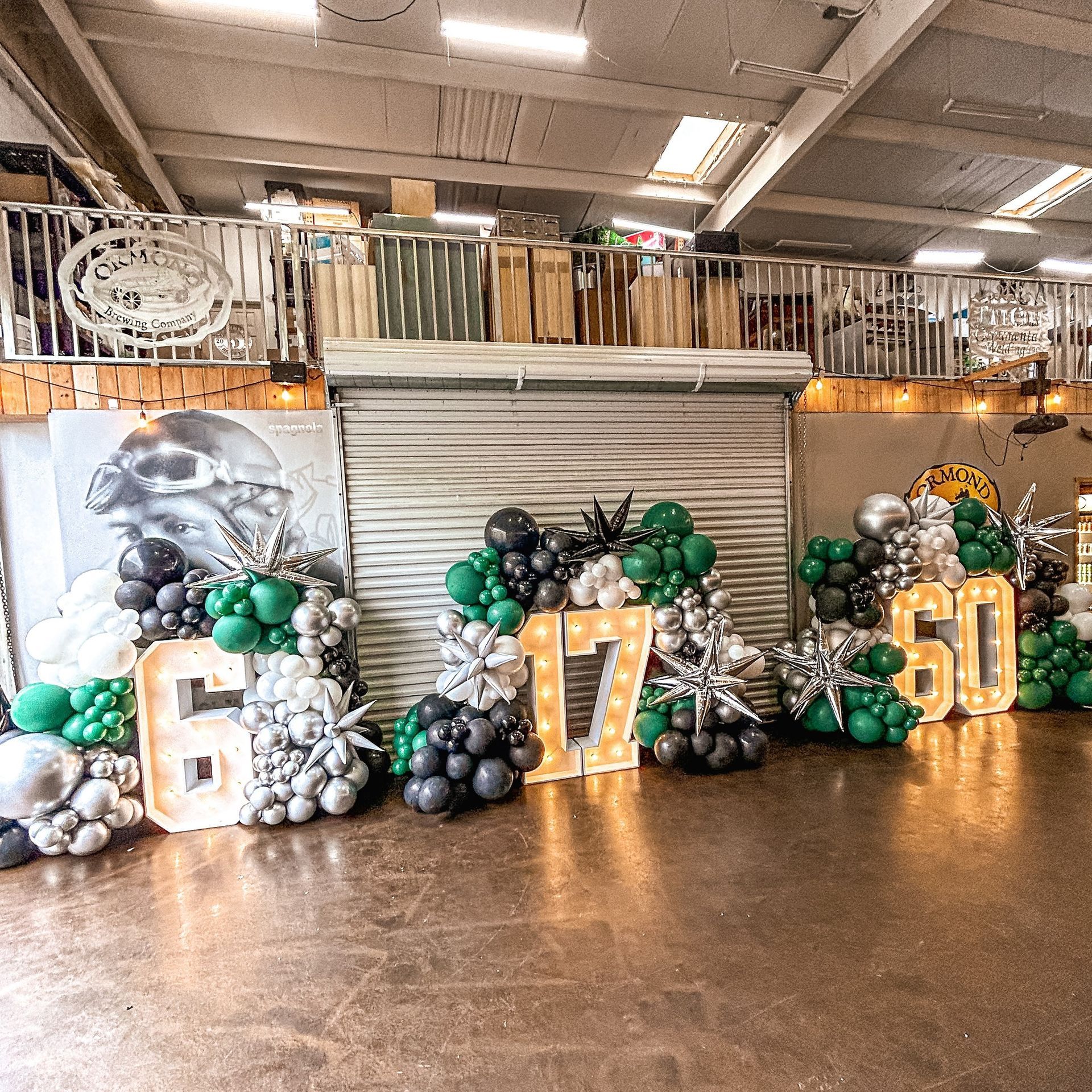 A room filled with balloons and lights and a sign that says 50.