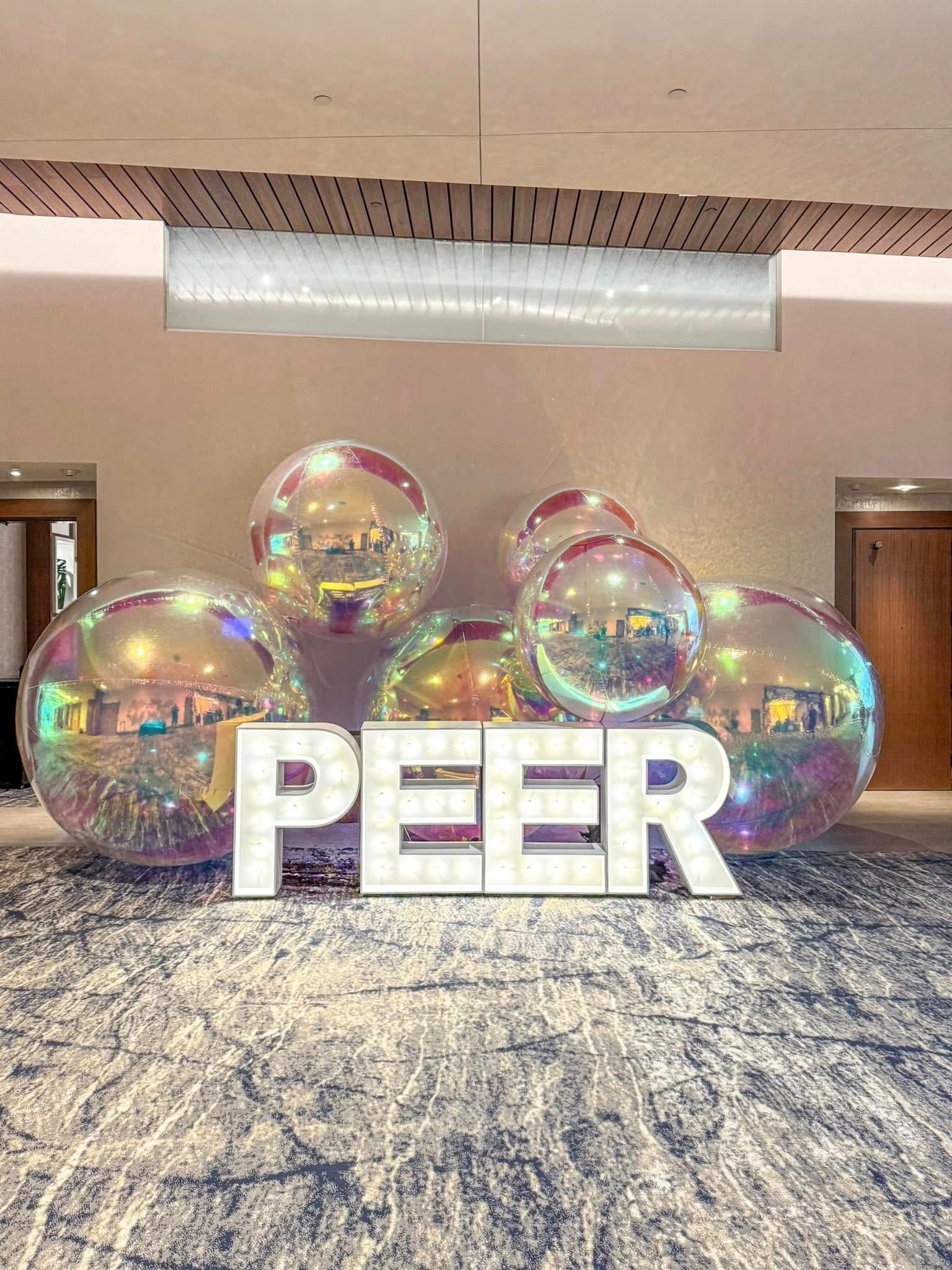 A room filled with balloons and a sign that says peer.