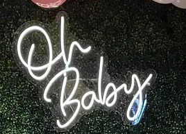 a neon sign that says `` oh baby '' is hanging on a wall .