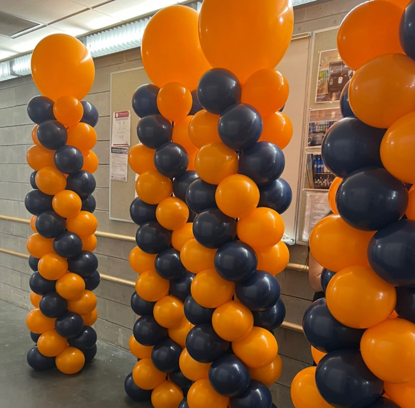 A bunch of orange and blue balloons stacked on top of each other