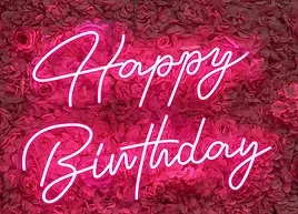 a neon sign that says `` happy birthday '' is surrounded by pink roses