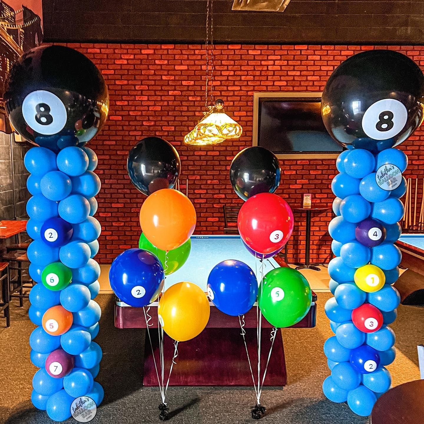 A pool table is decorated with balloons and pool balls