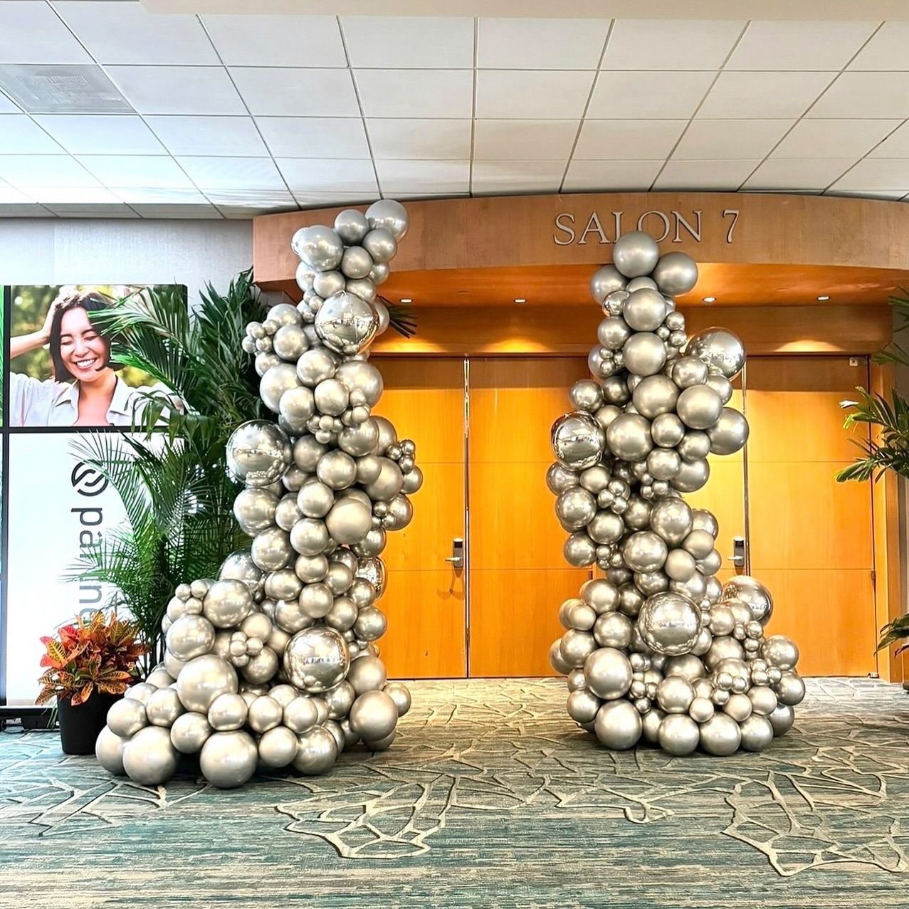 Two sculptures made of silver balloons are in front of the entrance to salon 7