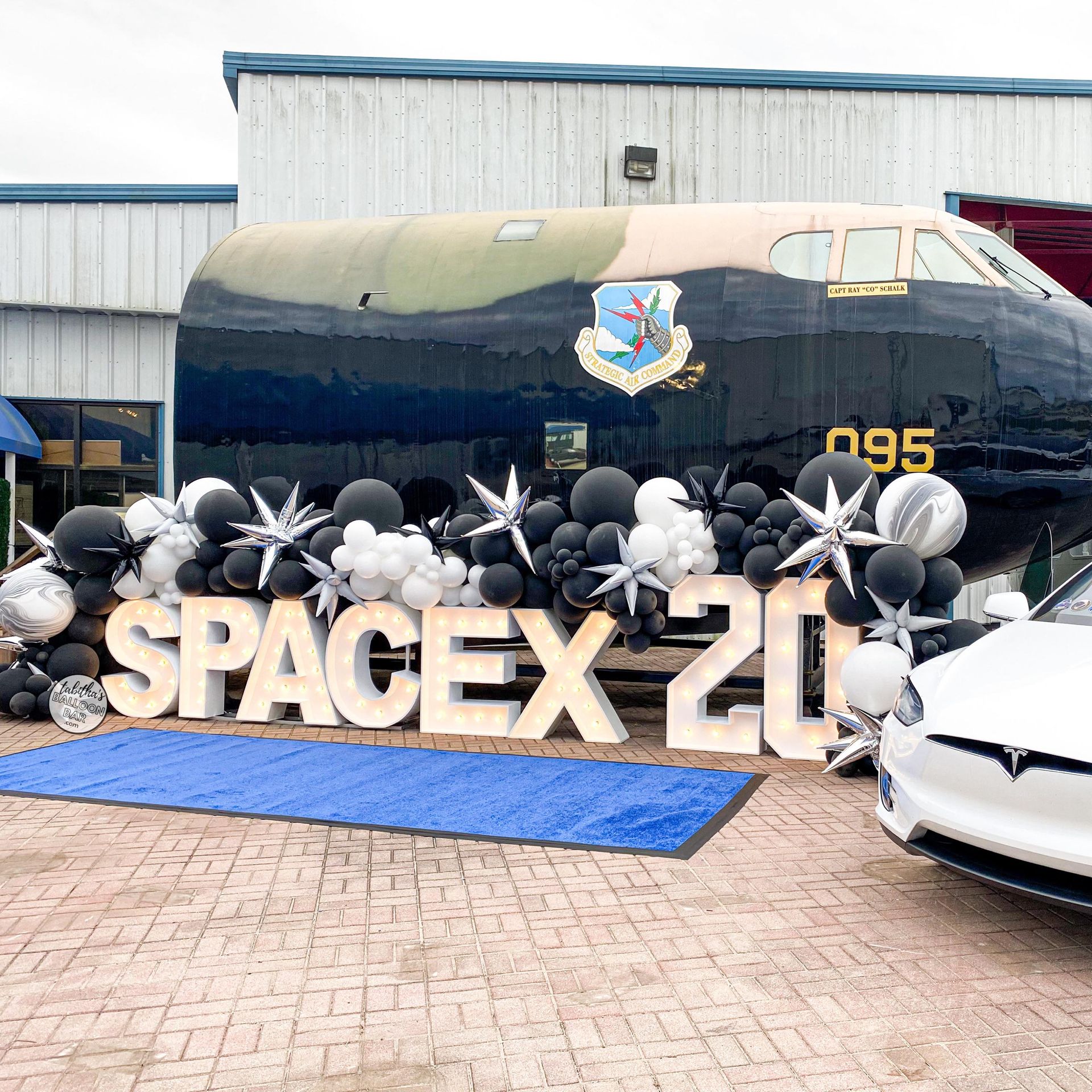 A plane is decorated with balloons and a sign that says spacex 21.