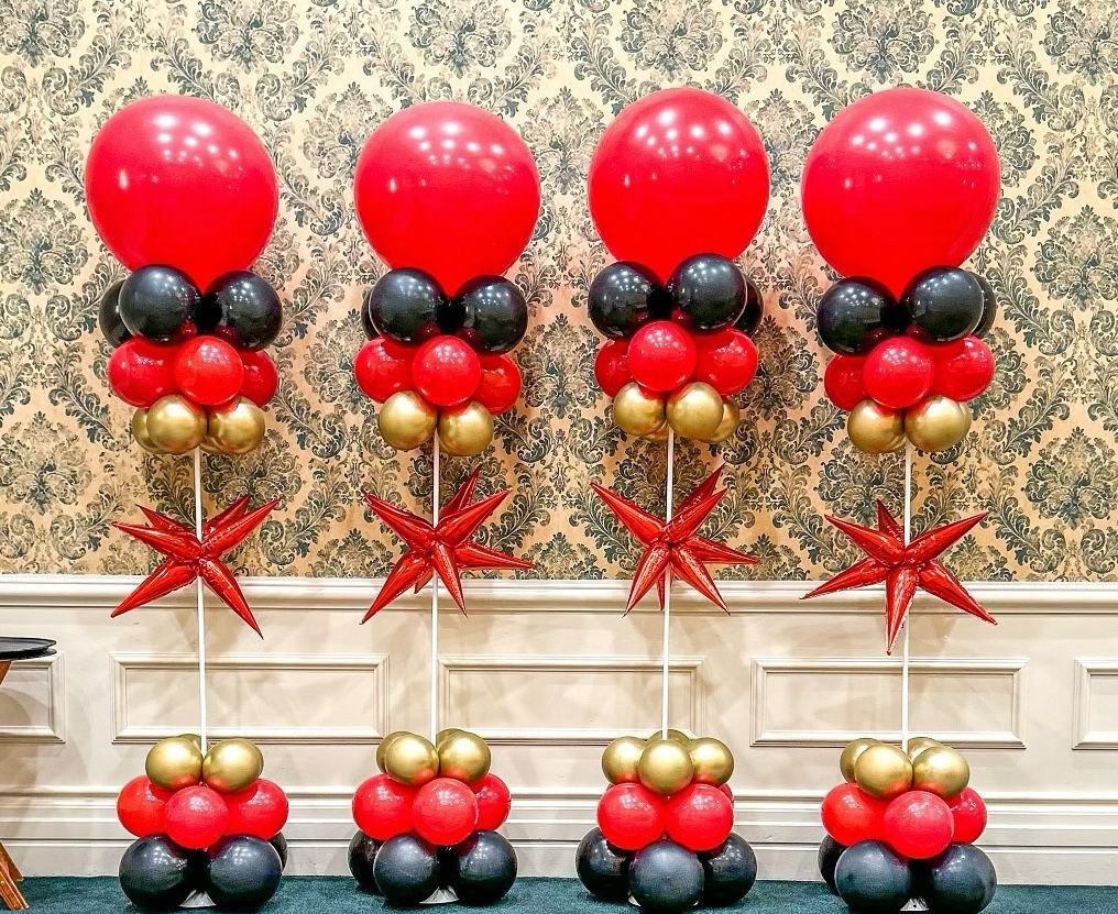 Three columns of blue , purple , and silver balloons with stars on them.