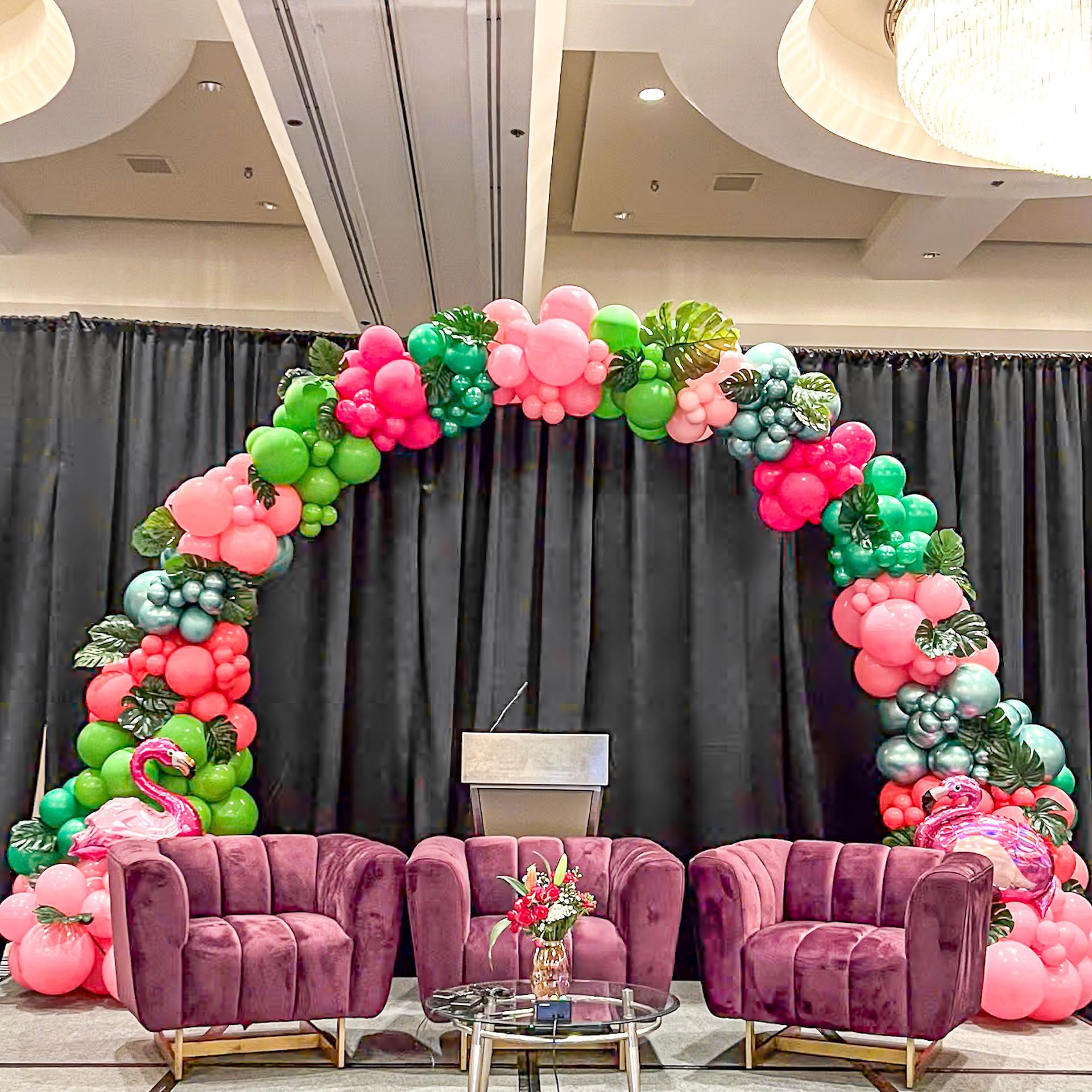 A room decorated with balloons and chairs and a podium.