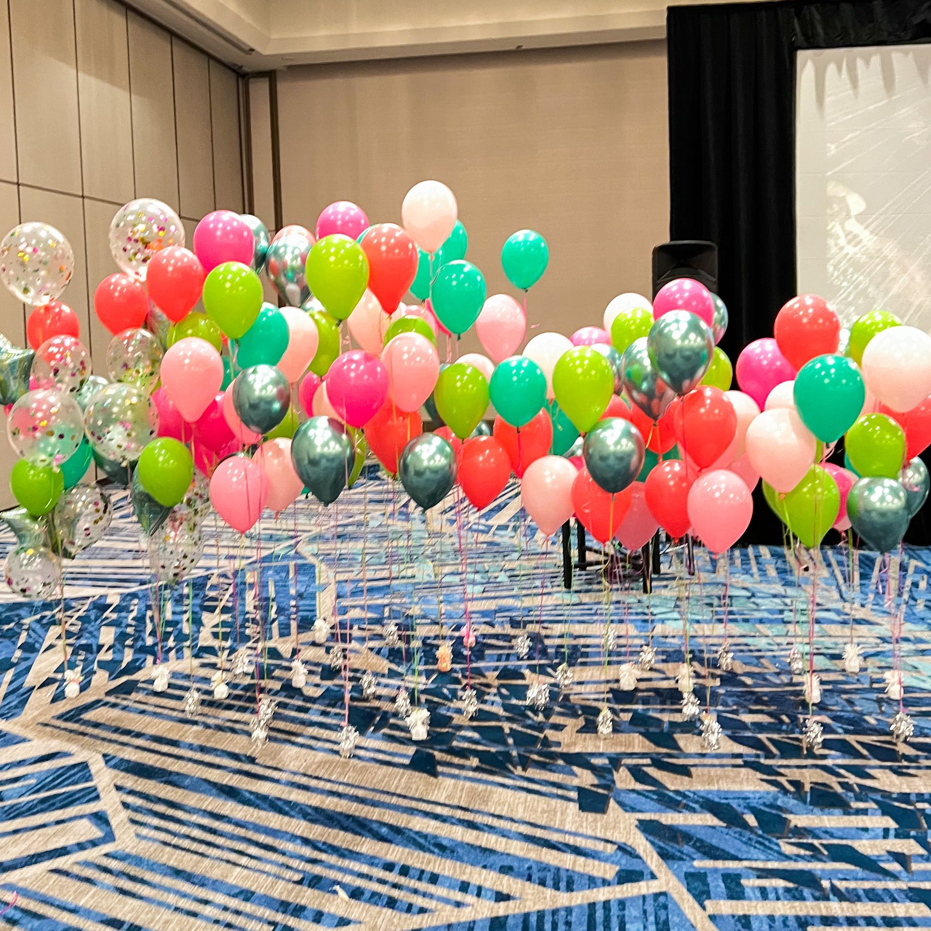 A bunch of balloons are floating in the air in a room