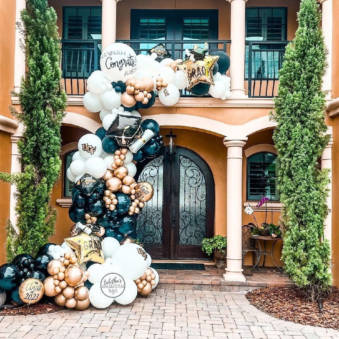 A bunch of balloons are sitting in front of a building.