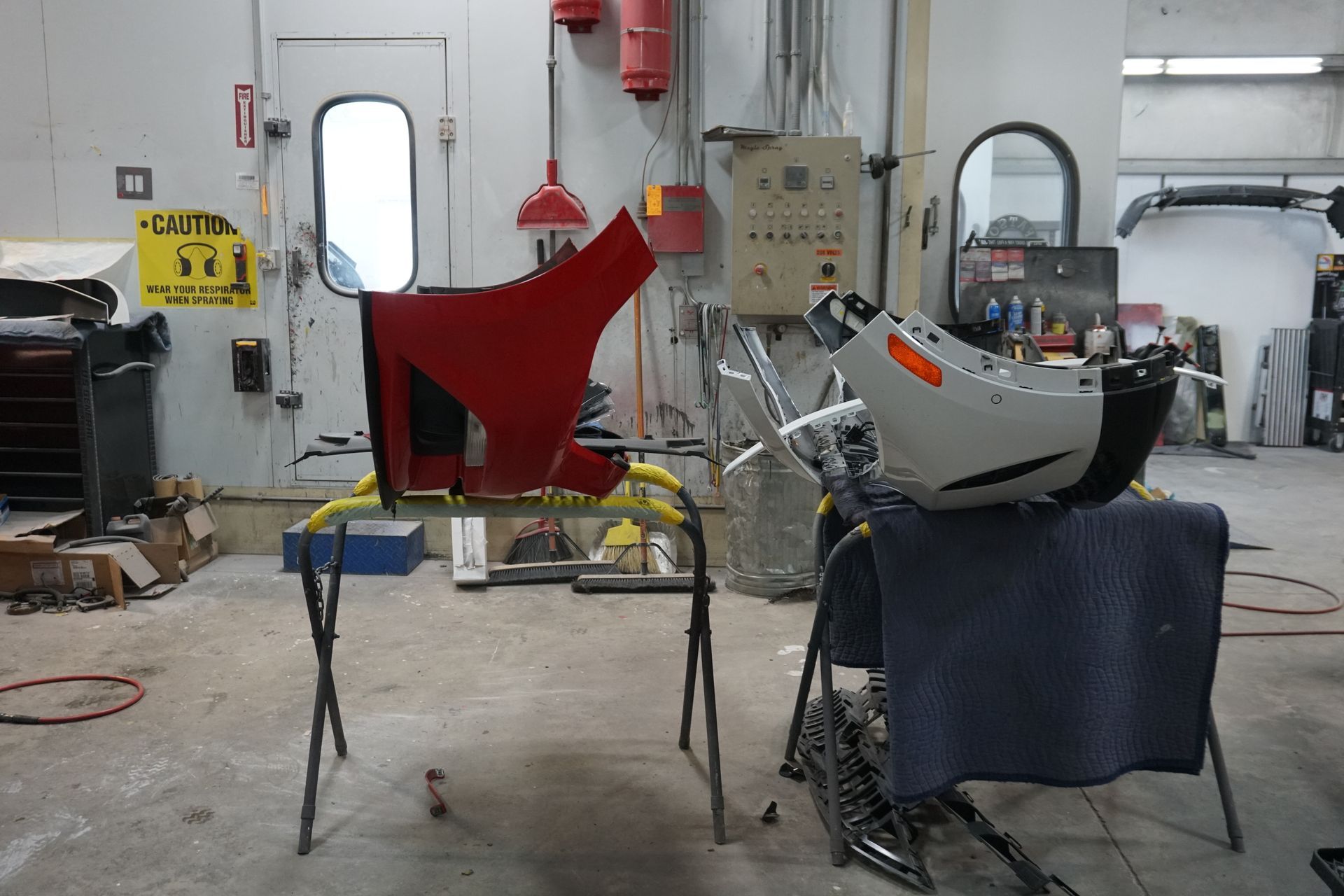 A person using dent removal tools on a car roof in a repair shop.