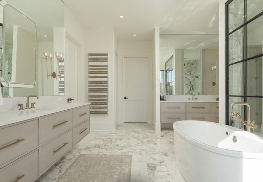 Spacious, modern bathroom with a double vanity, marble floors, and a freestanding tub.