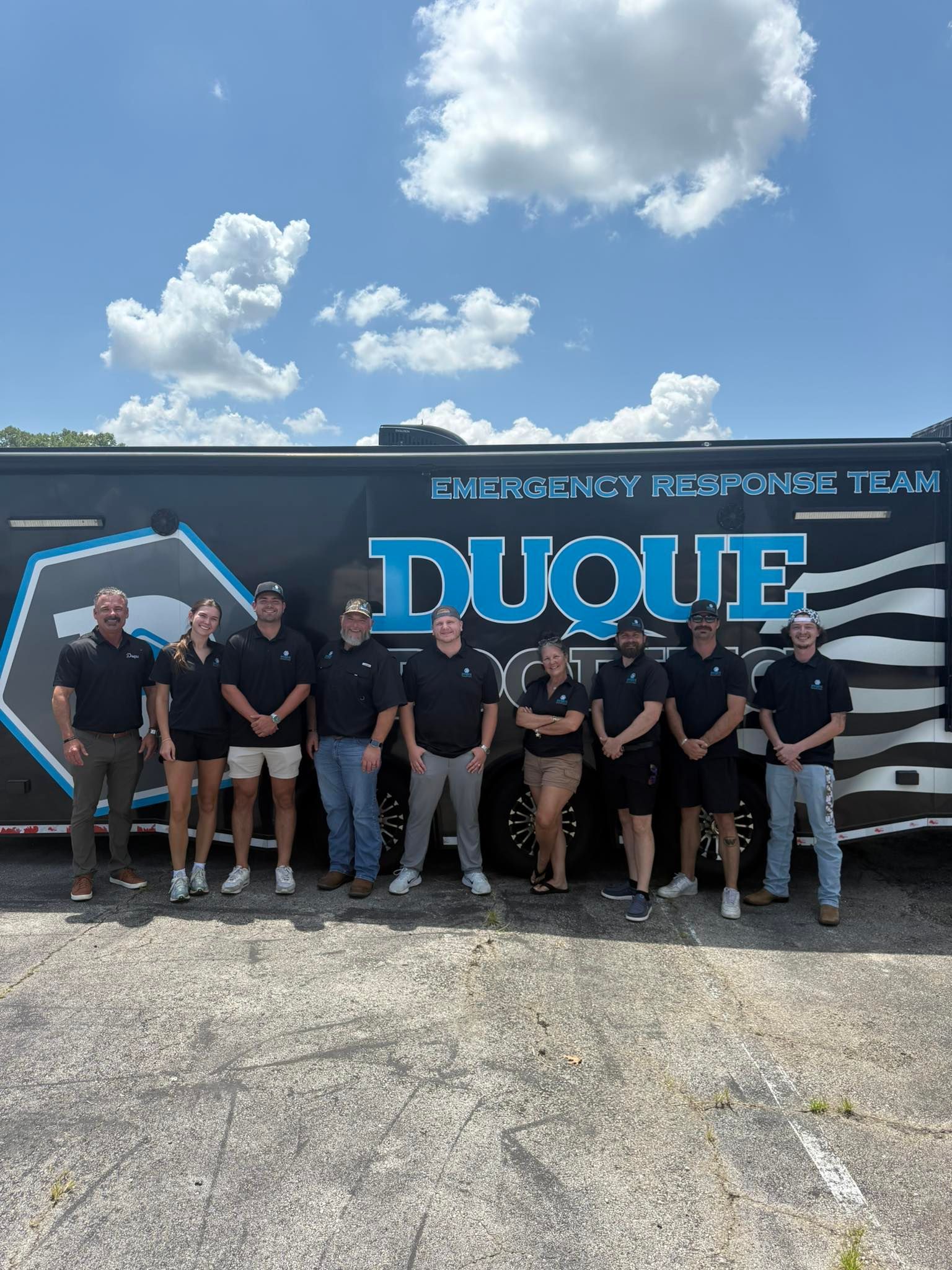 Group of people in matching shirts standing in front of a trailer that says