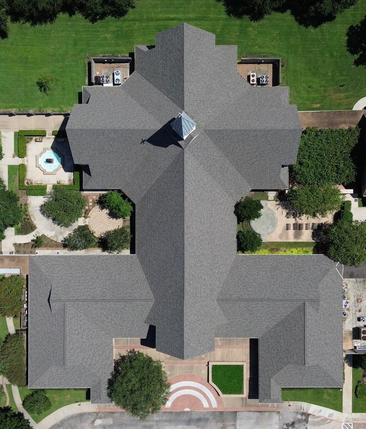 Rooftop with chimneys and a partial wood board covering; sunny day, urban background.