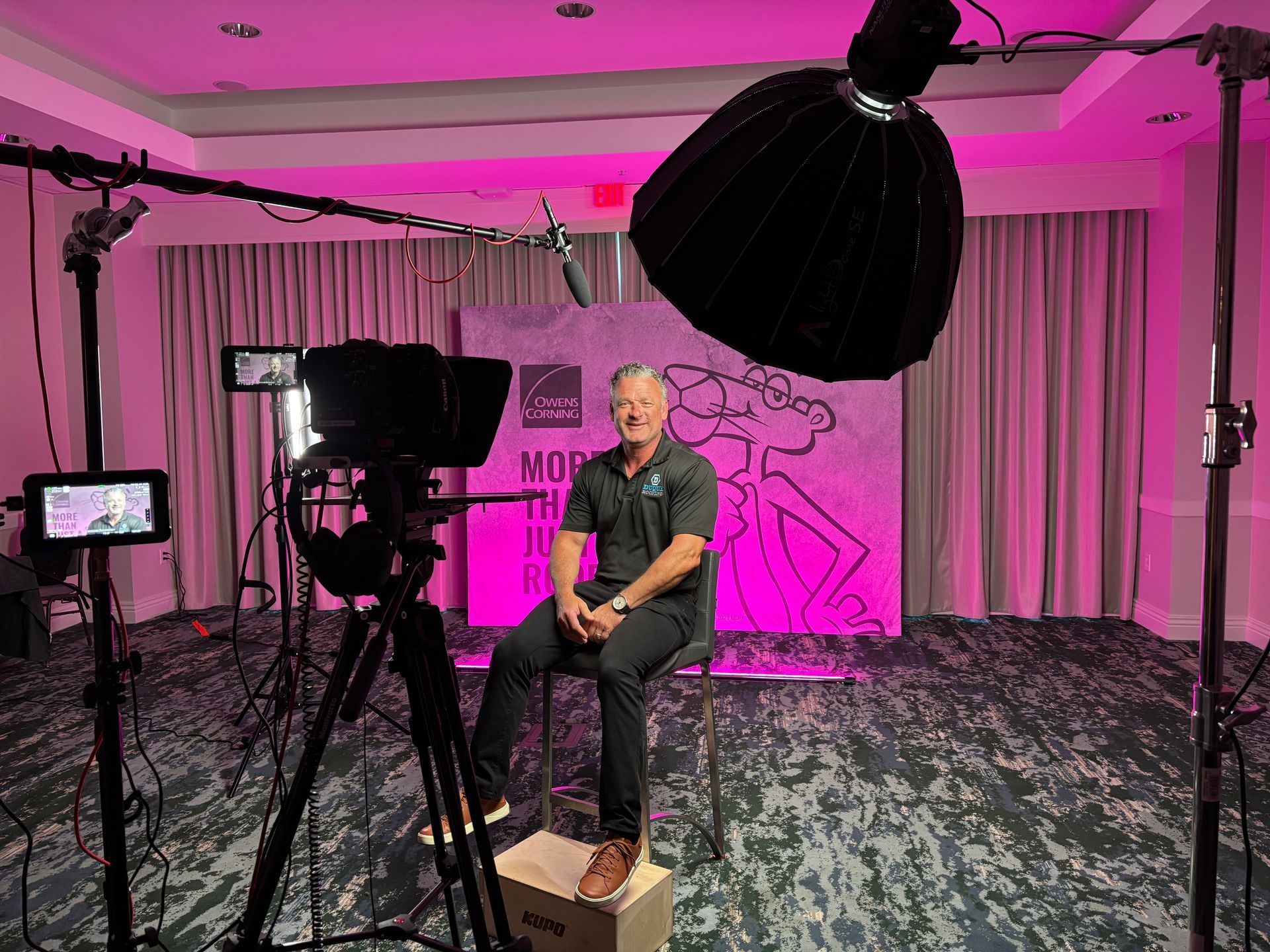 House with gray and green metal roofs under a sunny blue sky.