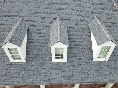 Three dormers with windows on a gray shingled roof.