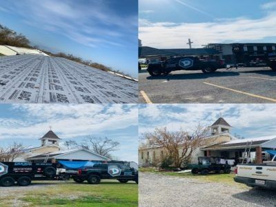 A church with work vehicles parked outside and a snowy roof in the distance. Blue sky overhead.