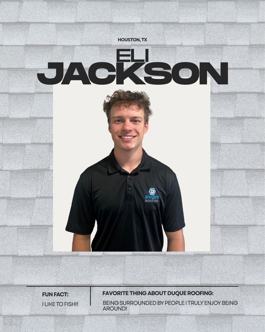 Eli Jackson posing, wearing a black shirt, for Dugue Roofing. Grey roof background.