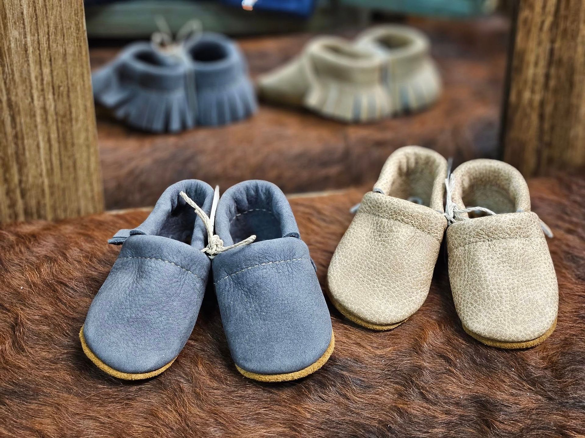 Two shoes are sitting next to each other on a brown surface.