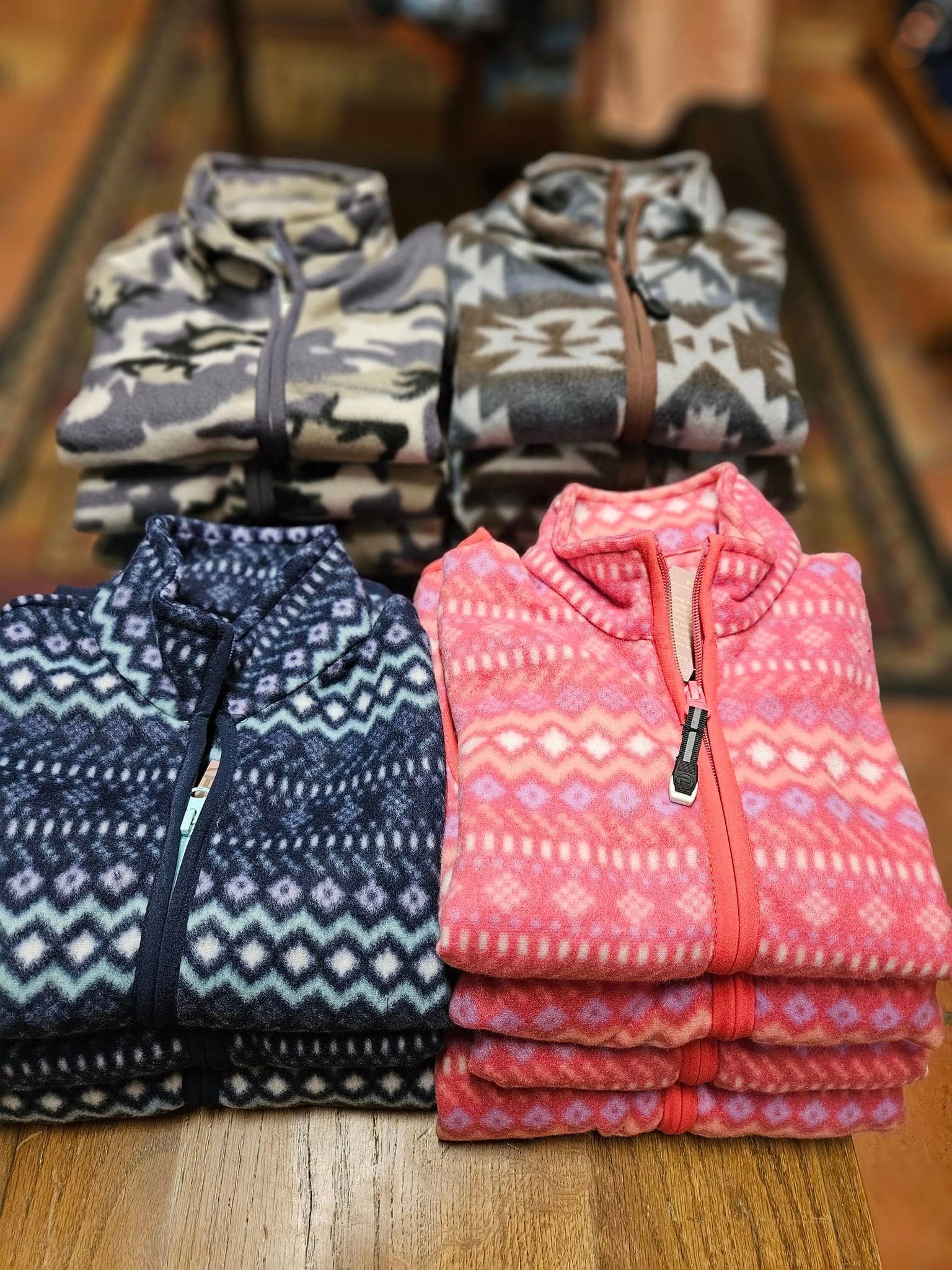 A stack of sweaters sitting on top of a wooden table.