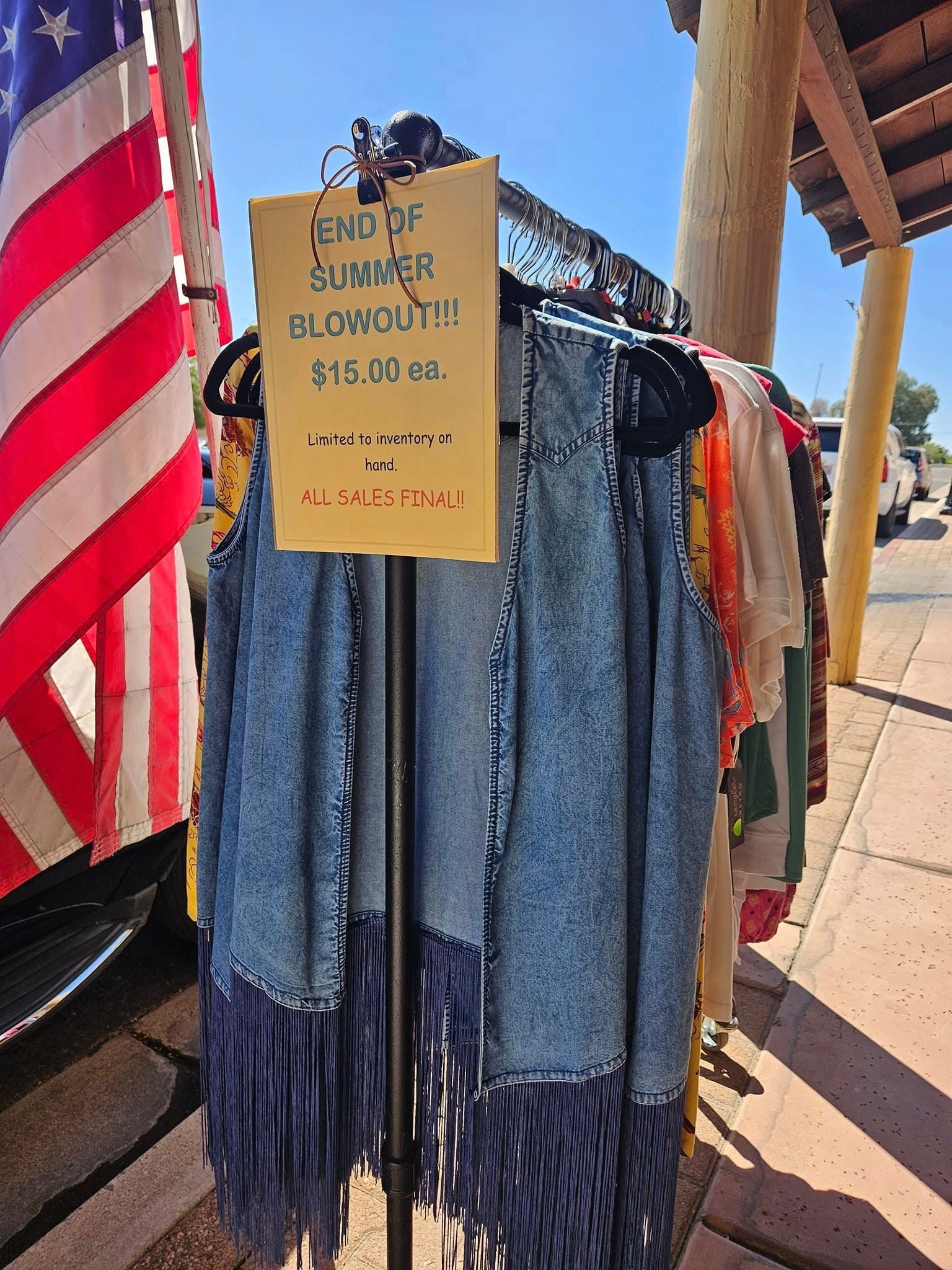 A denim vest with fringe and a sign that says end of summer blowout