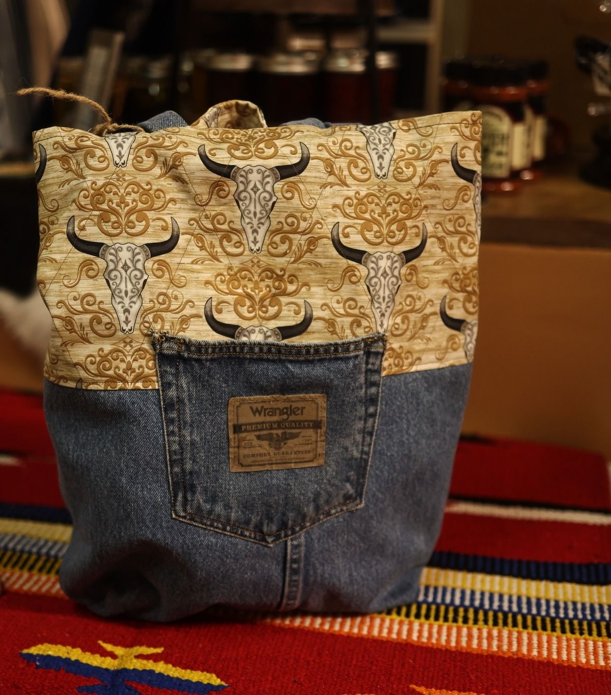A denim tote bag with bull skulls on it