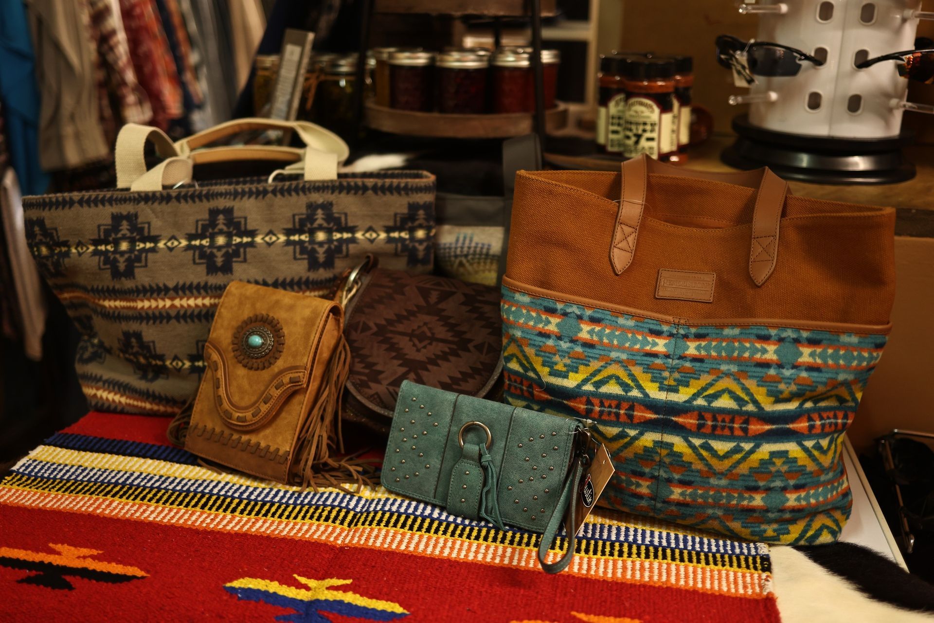 A variety of bags and wallets are sitting on a table.