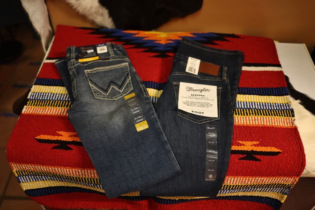 A pair of wrangler jeans sitting on top of a blanket