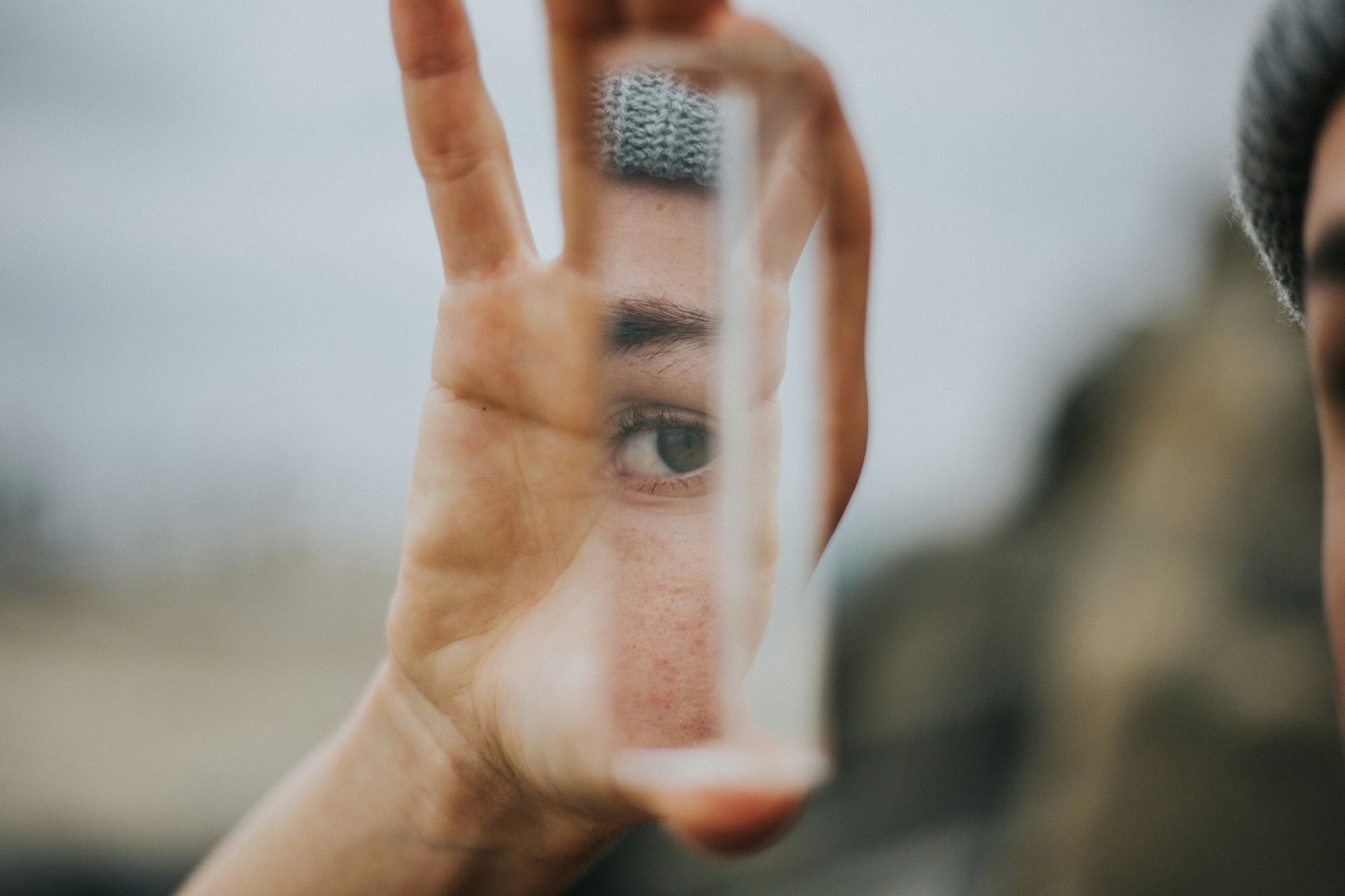 A person is holding a mirror in their hand and looking at their reflection.