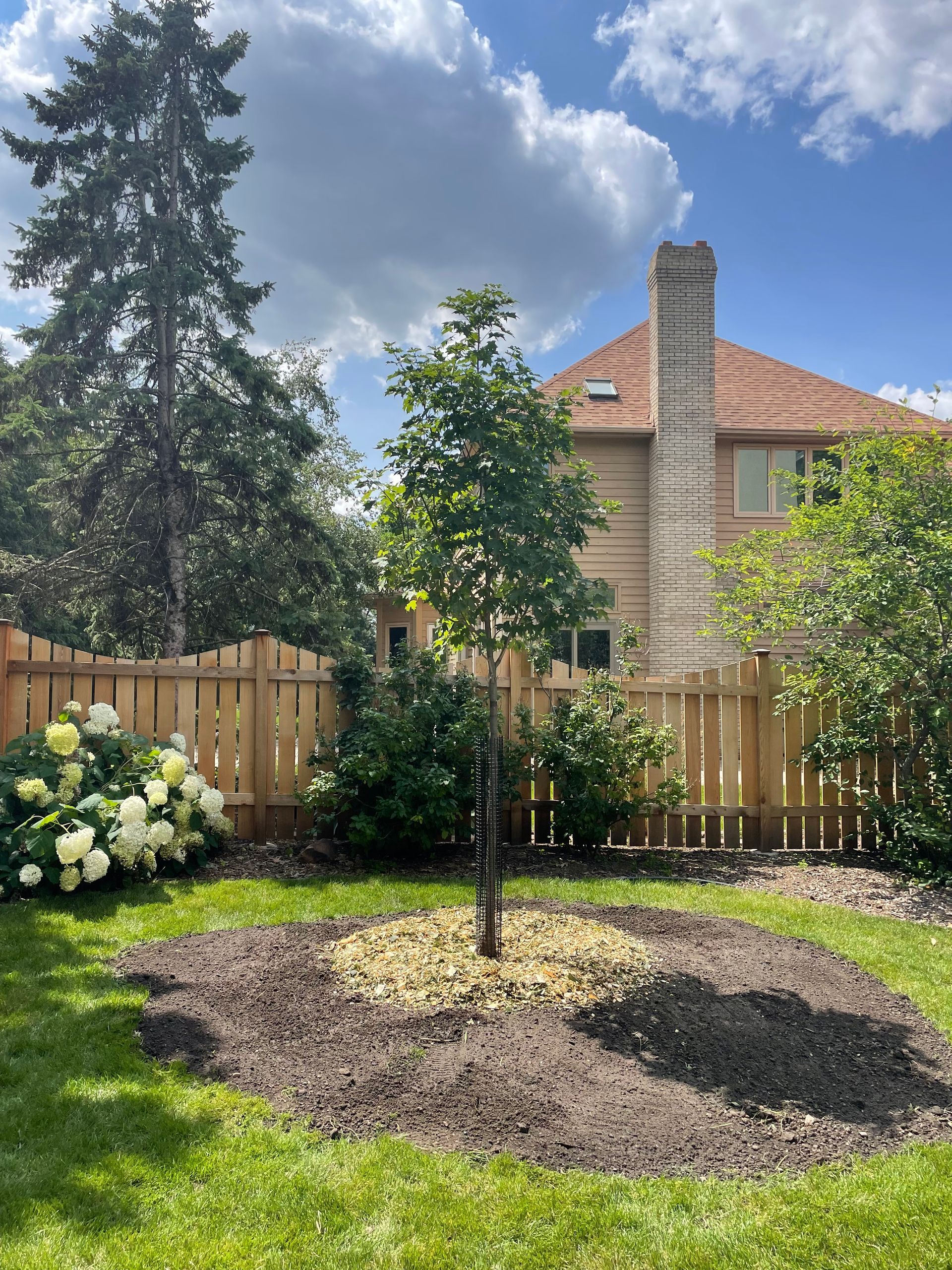 There is a brick patio in the backyard of a house.