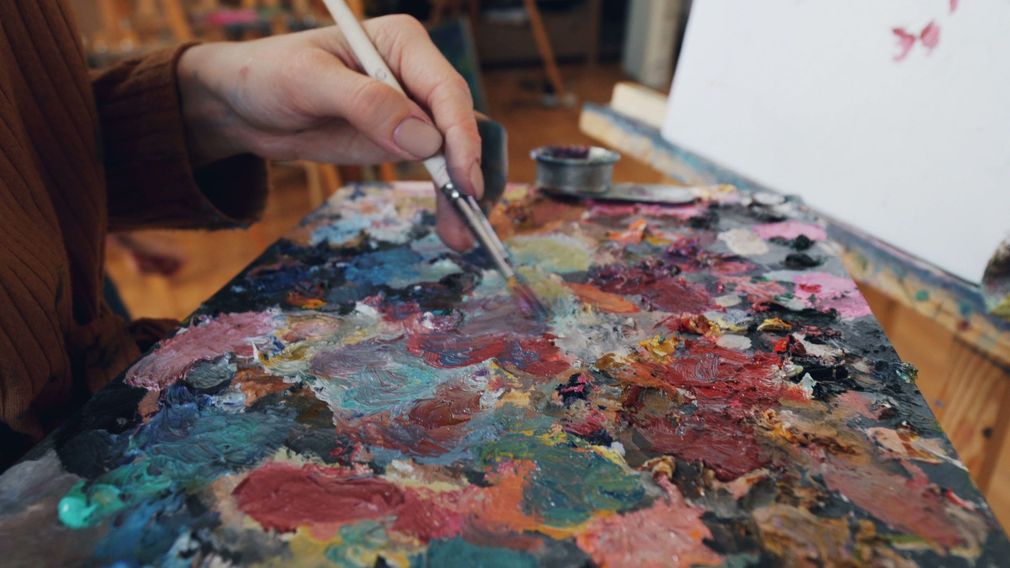 Open sets aquarelverf met diverse kleurrijke verfpanjes en penselen.