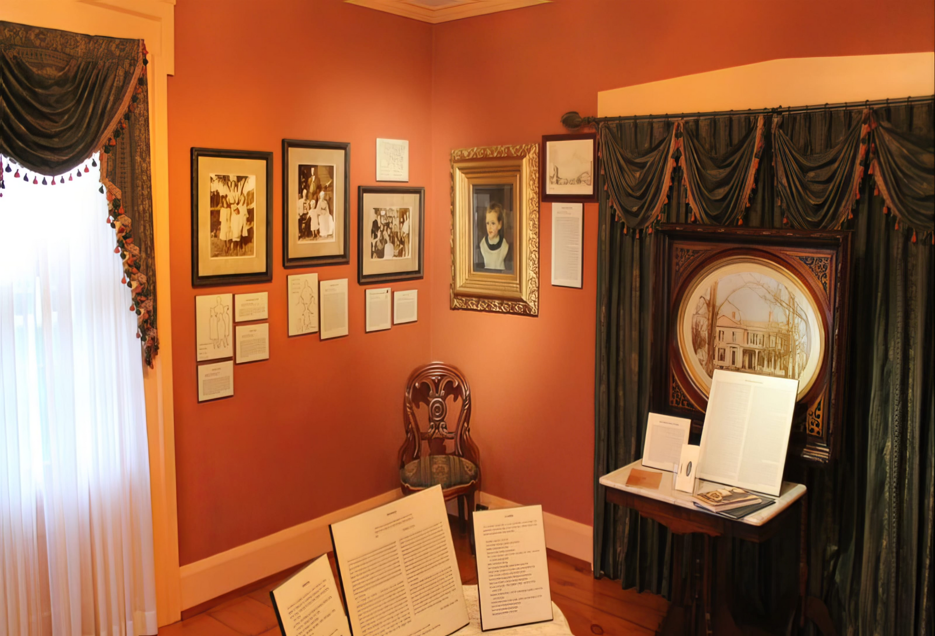 A room with pictures on the wall and a table with papers on it