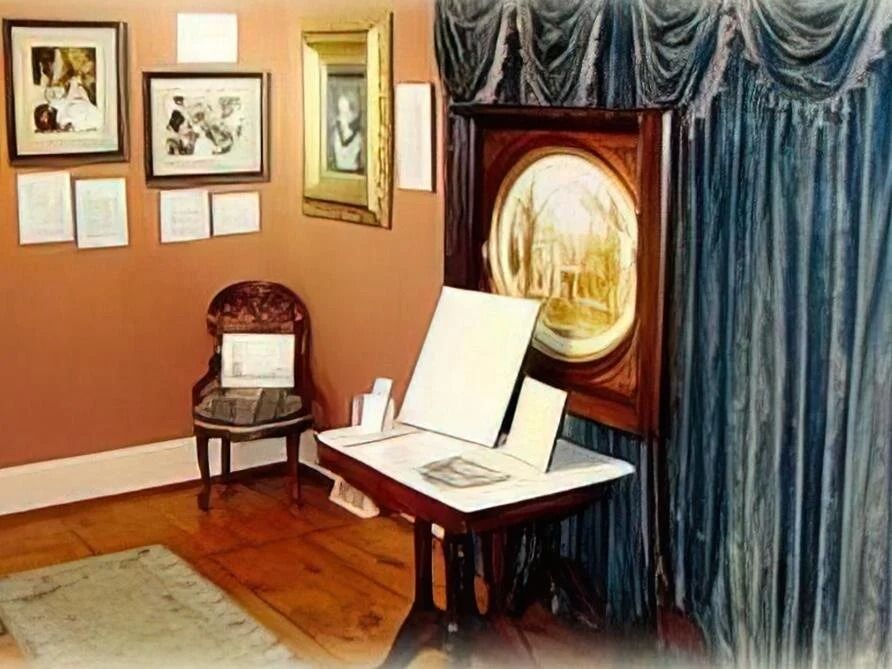 A room with pictures on the wall and a table and chair