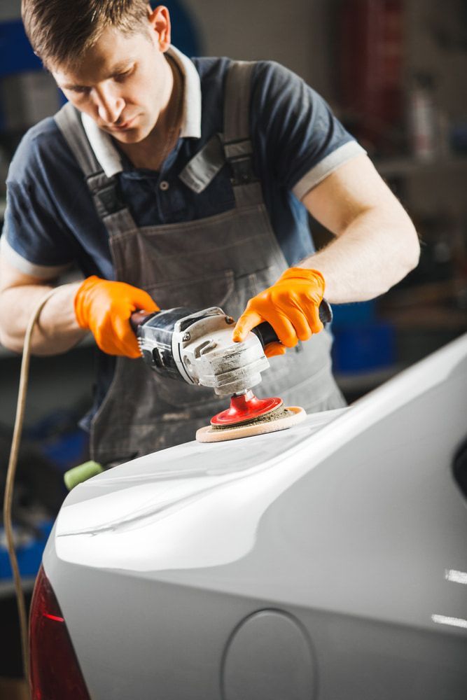 A Man is Polishing a Car With a Machine — Stengels Crash Repairs In Garbutt, QLD