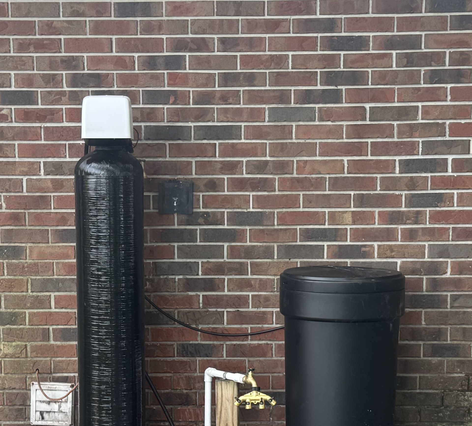 A water filter is sitting inside of a cabinet.