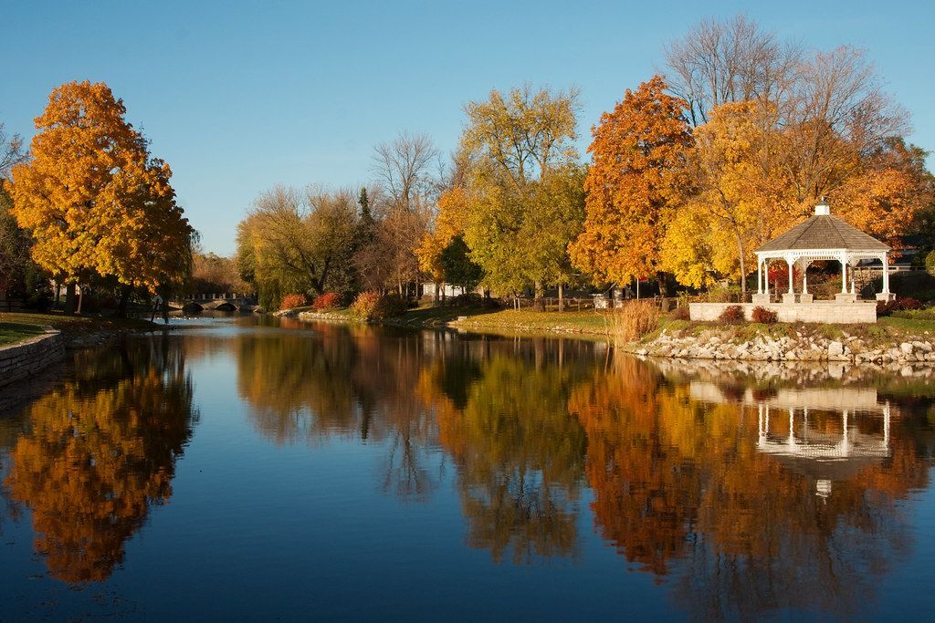 There is a gazebo in the middle of a lake surrounded by trees.