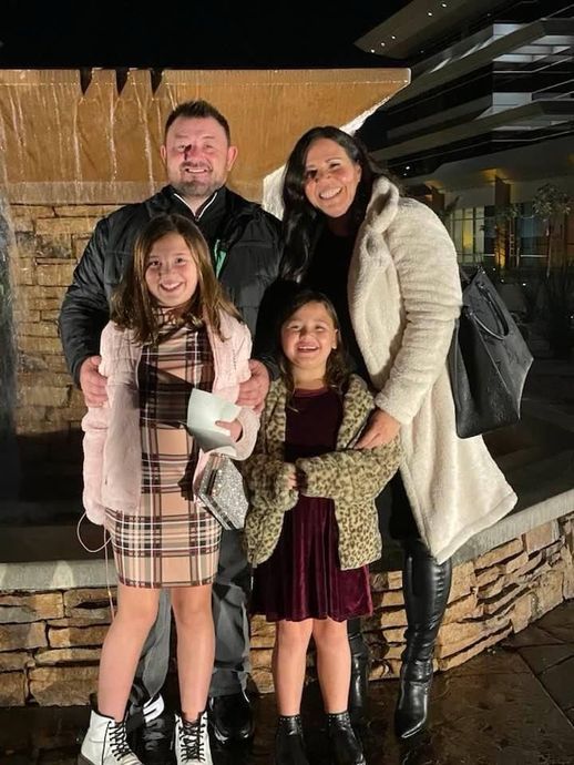 joe huljak from joonago mortgage and his family is posing for a picture in front of a waterfall.