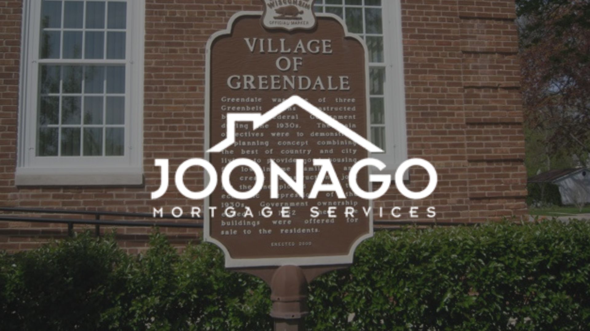 Sign for the Village of Greendale with Joonago Mortgage Services logo overlaid.