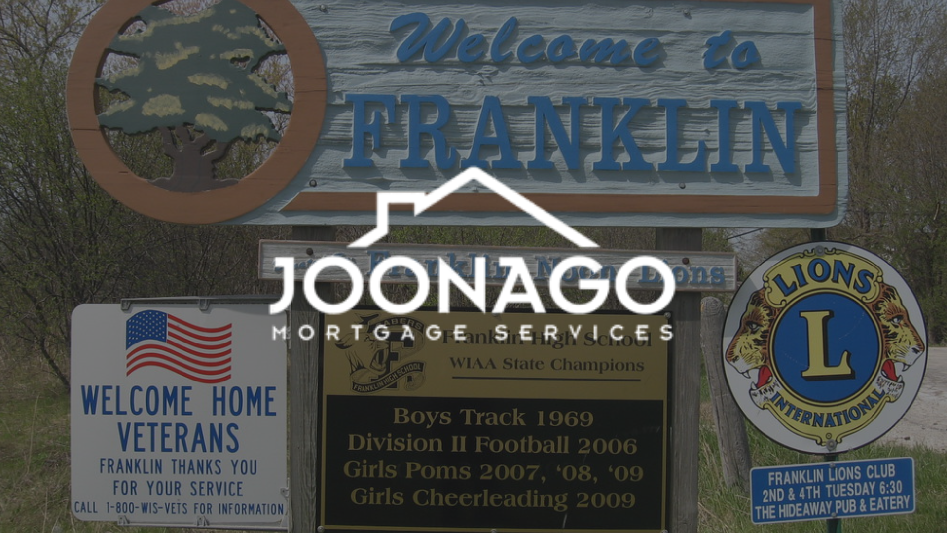 Welcome sign for Franklin, with several other signs and a logo overlay.