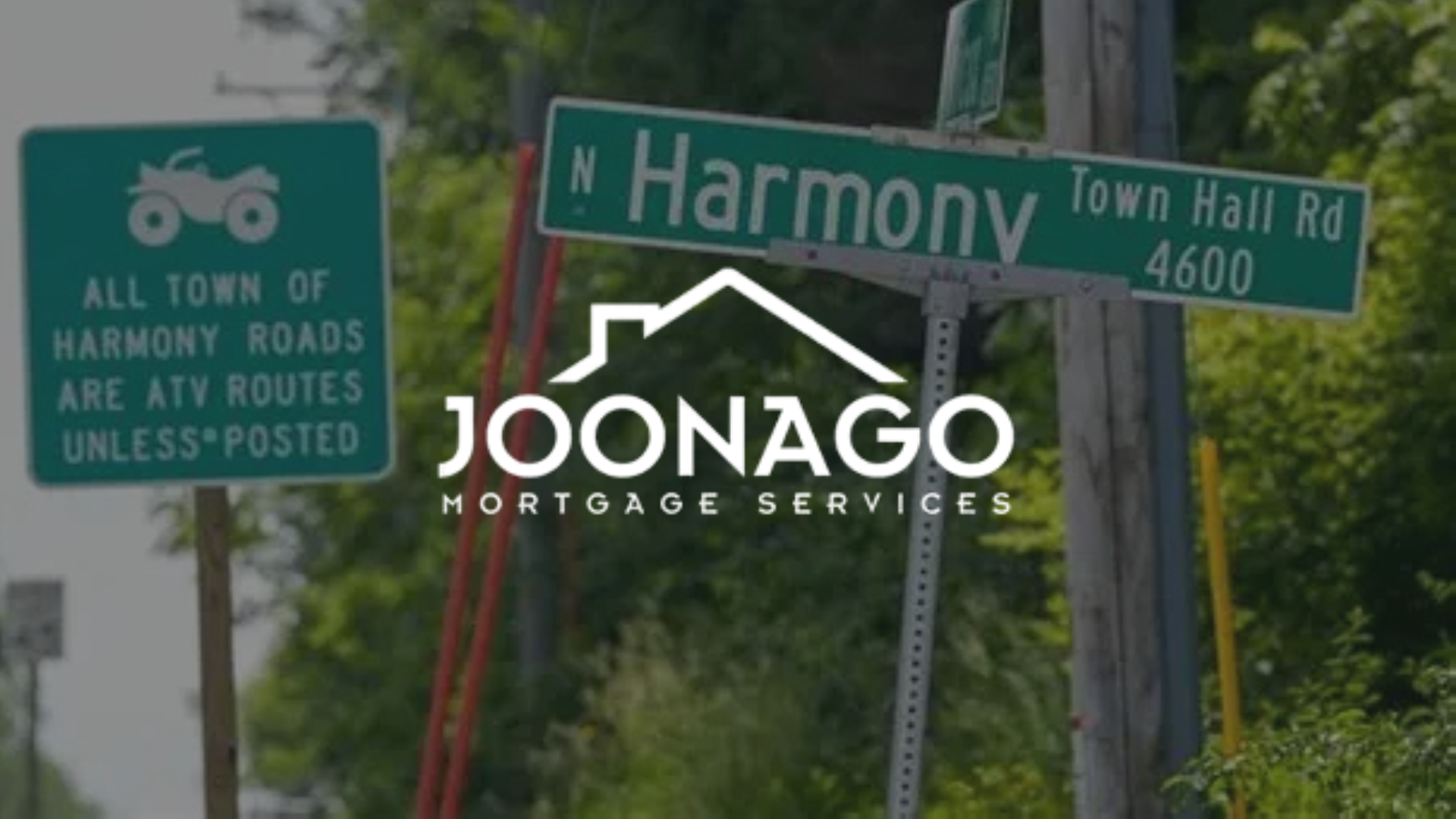 A street sign for harmony wi town hall road with joonago mortgage services logo on top