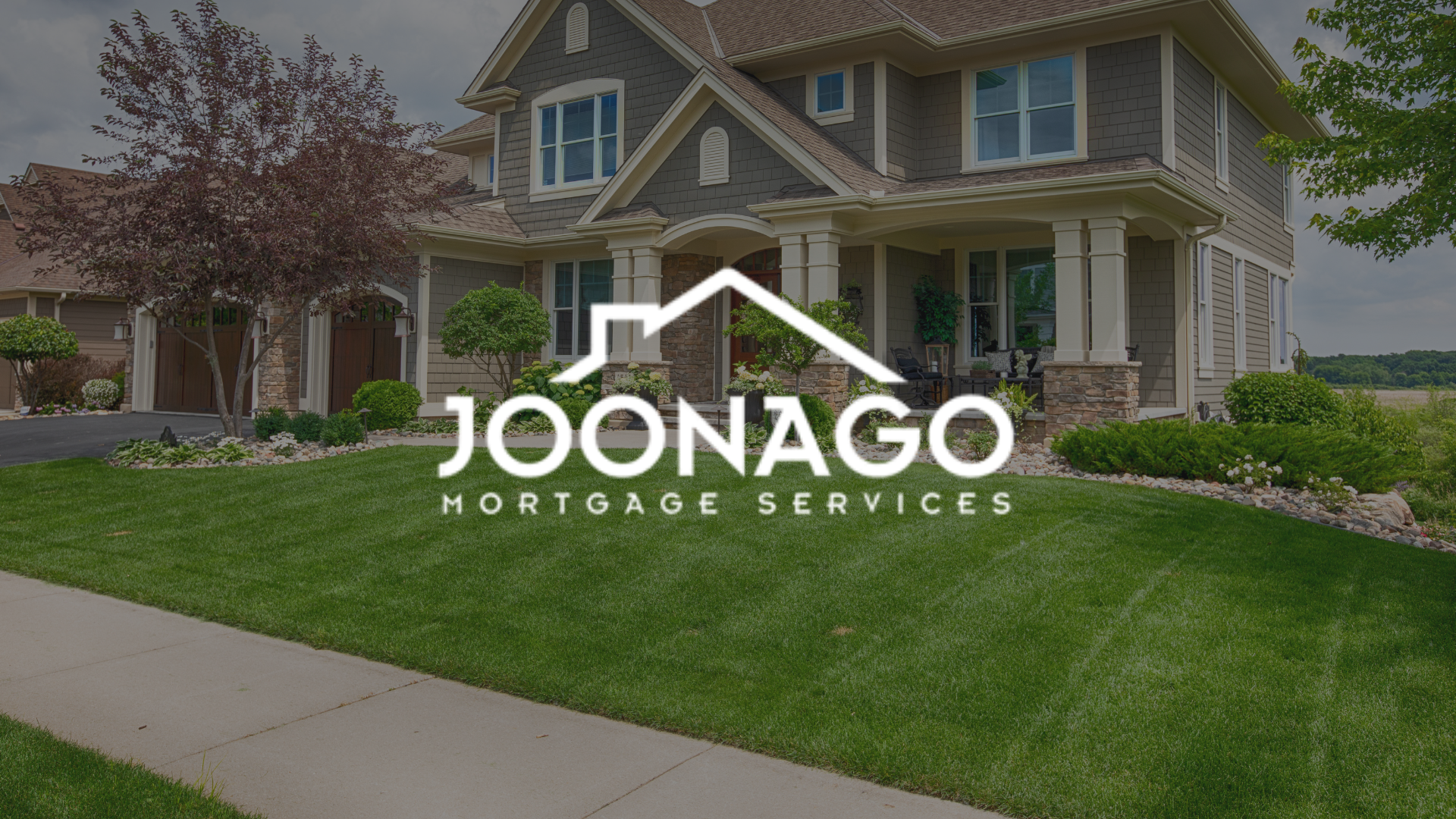A large brick house with a logo for joonago mortgage services in front of it.