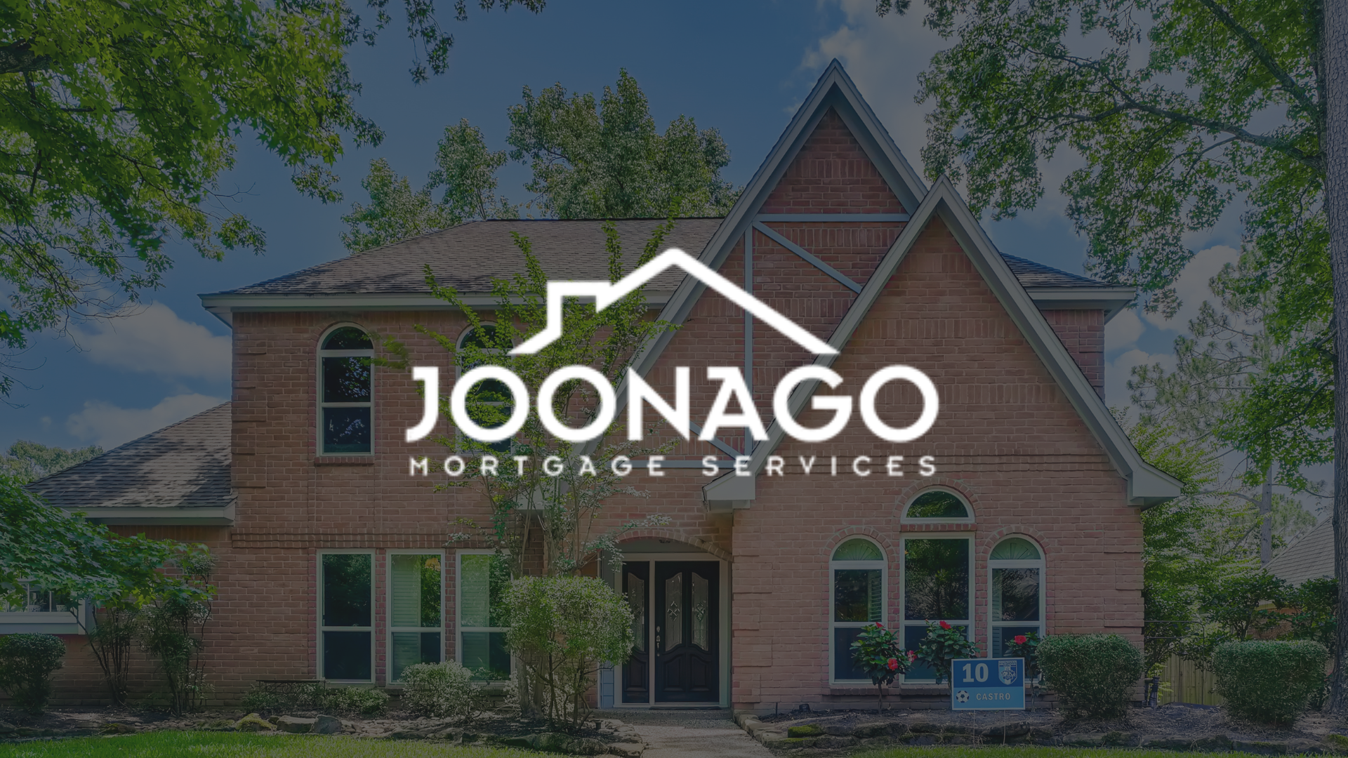 A large brick house with a logo for joonago mortgage services in front of it.