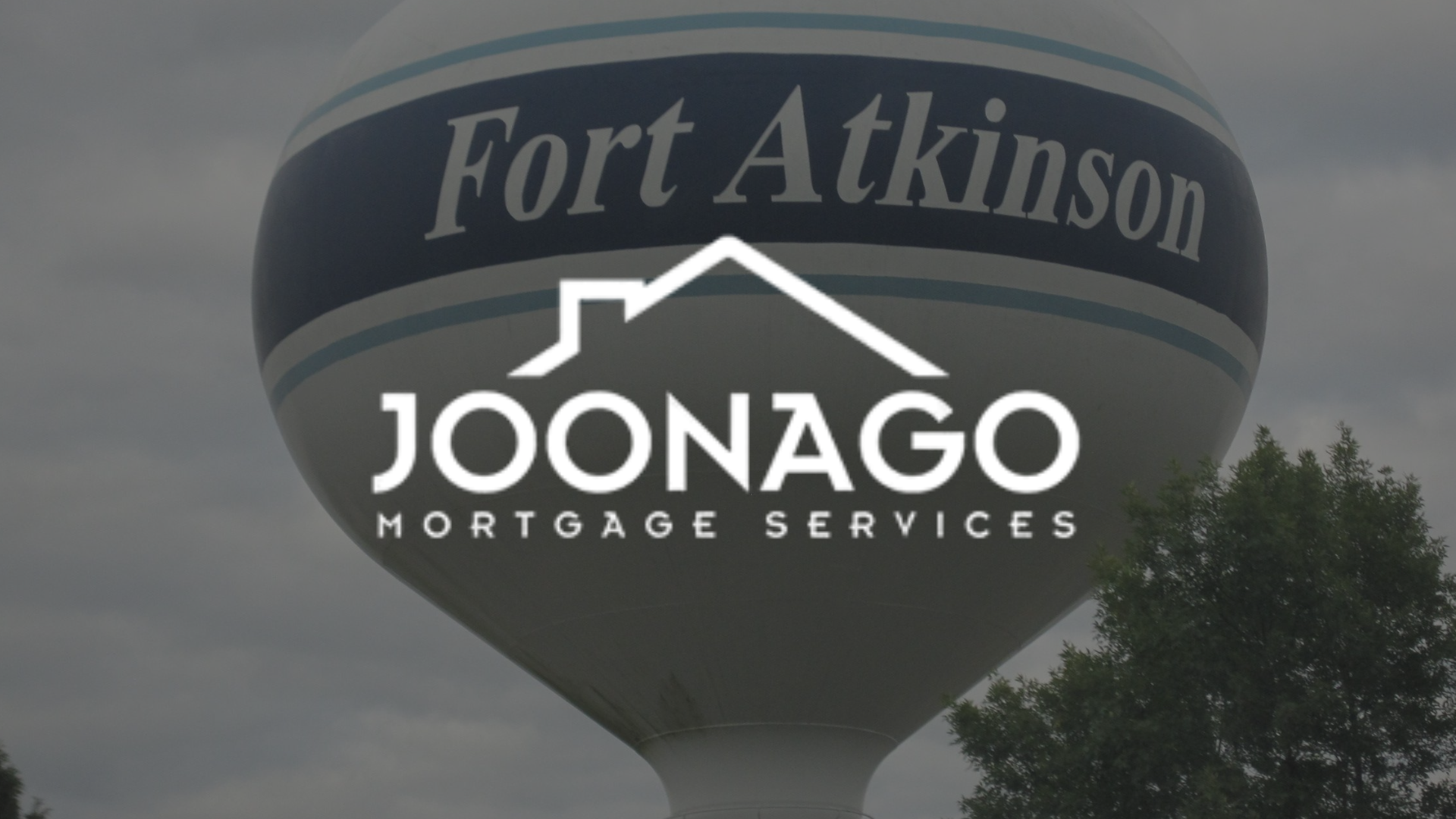 A water tower that says fort atkinson on it with joonago mortgage services logo on on top