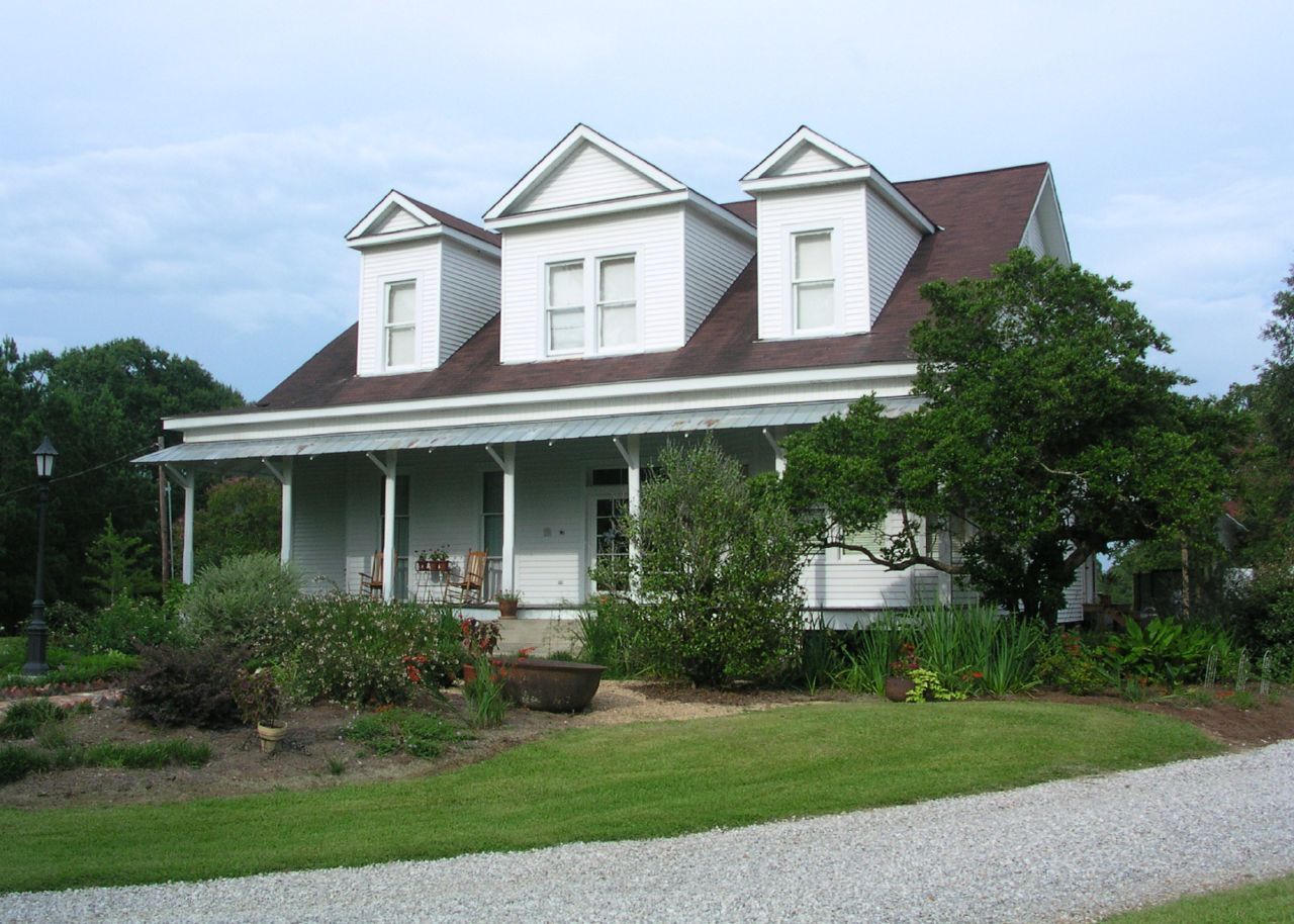 A large white house with three dormers and a porch